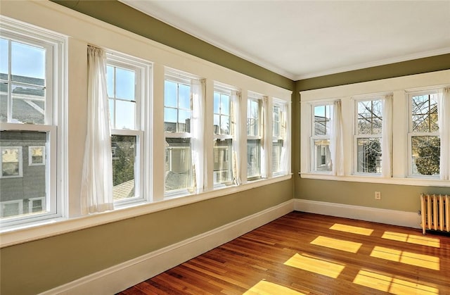 unfurnished sunroom featuring radiator heating unit