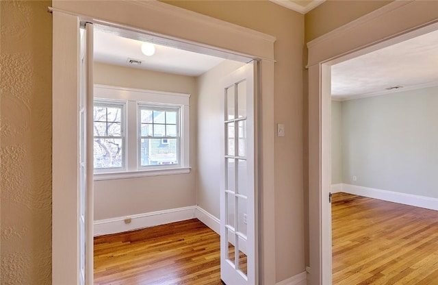 entryway with wood finished floors, visible vents, and baseboards