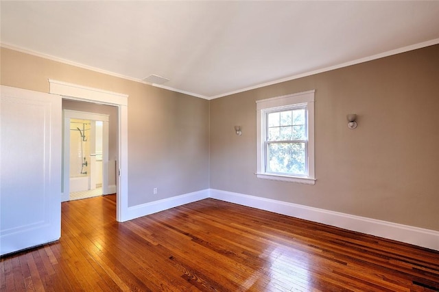 spare room with crown molding, baseboards, and hardwood / wood-style floors