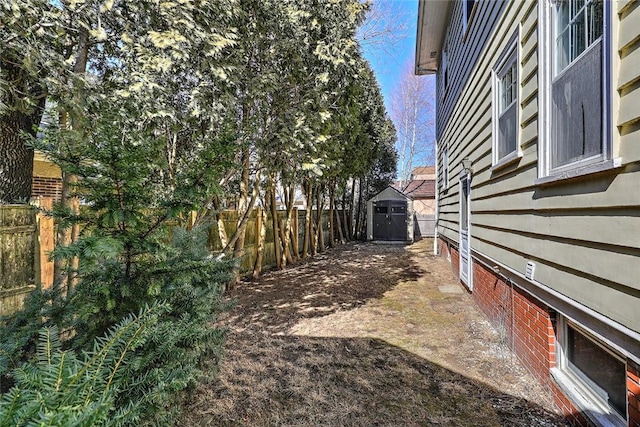 view of yard featuring a shed, an outdoor structure, and a fenced backyard