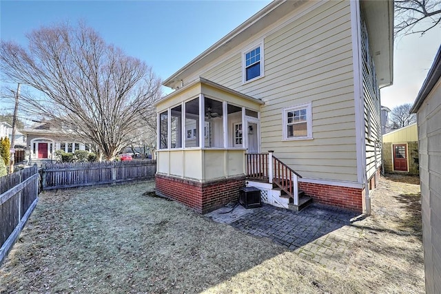 rear view of house with a sunroom and a fenced backyard