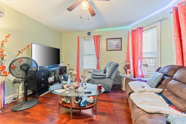 living area featuring a baseboard heating unit, a ceiling fan, and wood finished floors