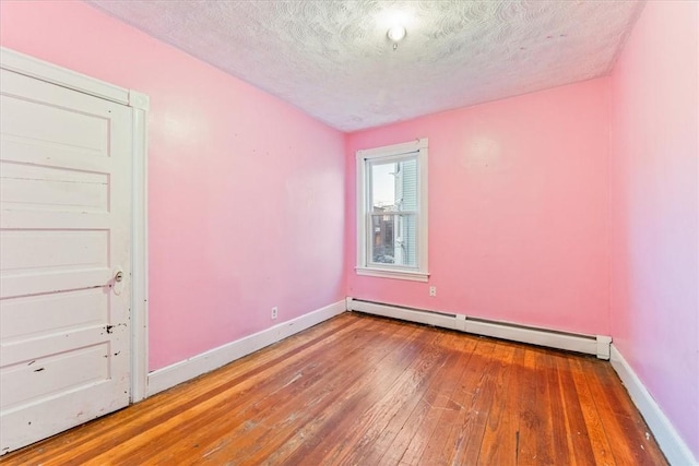 unfurnished room featuring a baseboard radiator, wood-type flooring, a textured ceiling, and baseboards