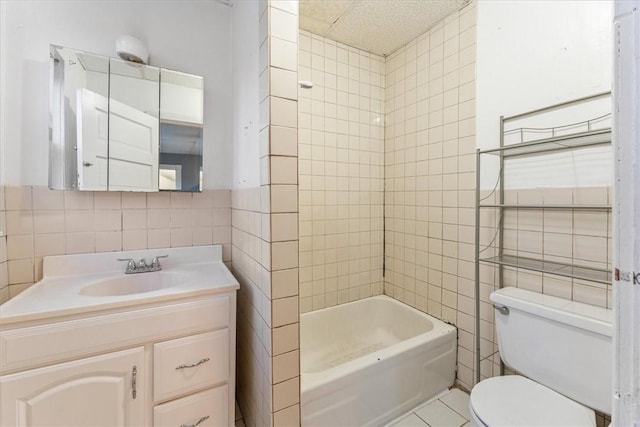 full bathroom with toilet, washtub / shower combination, tile walls, and vanity