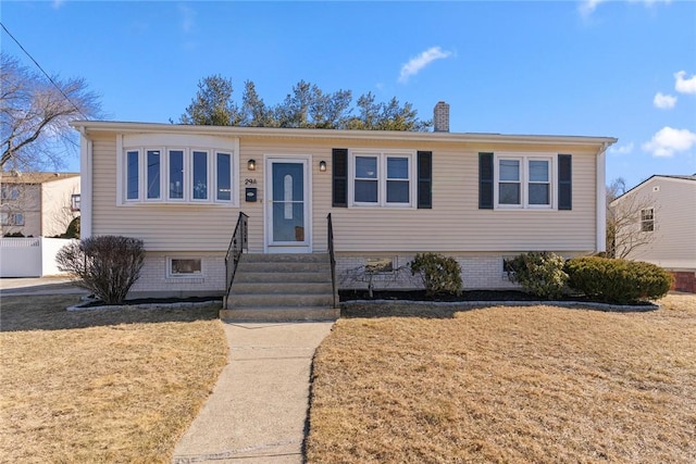 view of front of home with entry steps, a chimney, and a front lawn