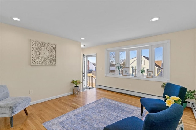 living area with recessed lighting, baseboards, baseboard heating, and wood finished floors