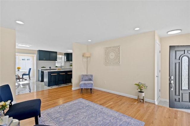 foyer entrance featuring light wood-style floors, recessed lighting, and baseboards