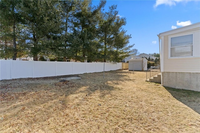 view of yard with a storage unit, fence, and an outbuilding