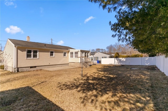 back of property with crawl space, a patio area, a fenced backyard, and a chimney