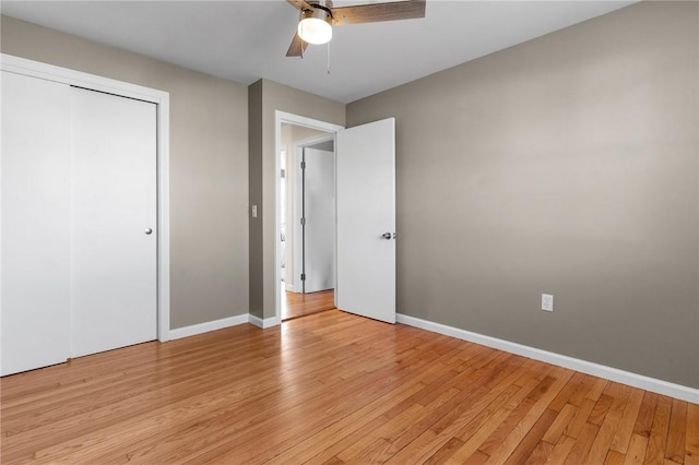 unfurnished bedroom with light wood-style floors, a closet, baseboards, and a ceiling fan