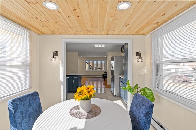 dining area featuring a baseboard heating unit, wooden ceiling, and baseboard heating