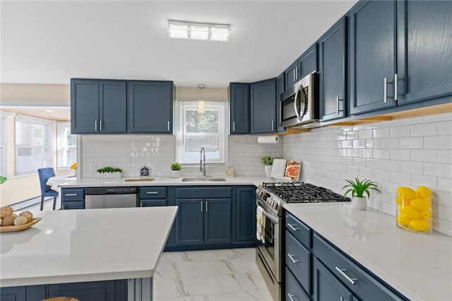 kitchen with marble finish floor, stainless steel appliances, a sink, and light countertops