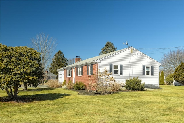 view of home's exterior featuring brick siding, a chimney, and a lawn