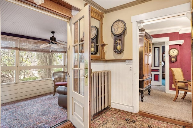 sunroom featuring a ceiling fan and radiator