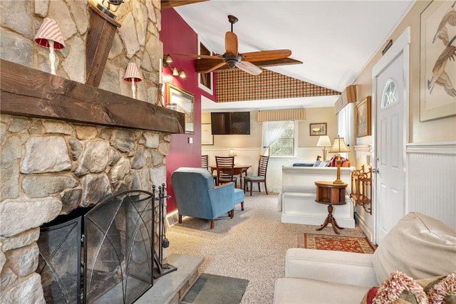 living area with a ceiling fan, lofted ceiling, a wainscoted wall, carpet flooring, and a fireplace