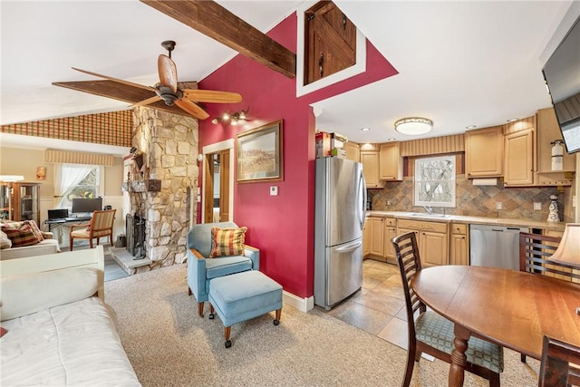 kitchen with lofted ceiling with beams, stainless steel appliances, light brown cabinets, and a healthy amount of sunlight