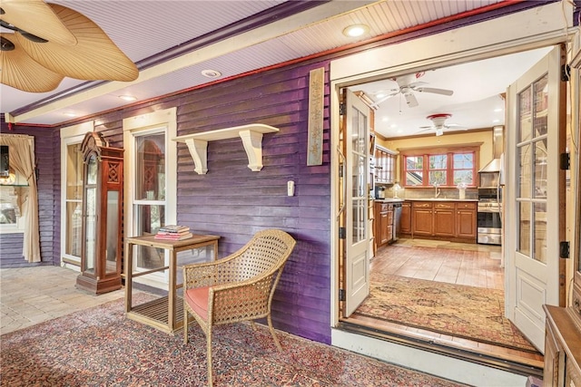 interior space featuring wooden walls, recessed lighting, a sink, and crown molding