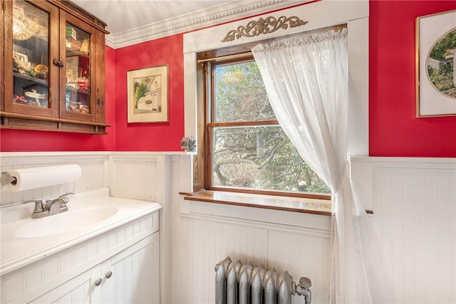 bathroom with radiator, a wainscoted wall, and vanity