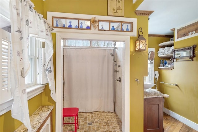 bathroom with baseboards, wood finished floors, and a shower with shower curtain