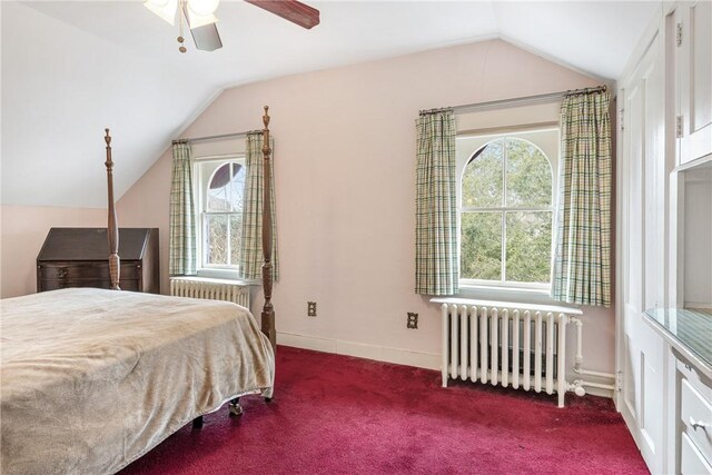 carpeted bedroom featuring multiple windows, vaulted ceiling, and radiator heating unit