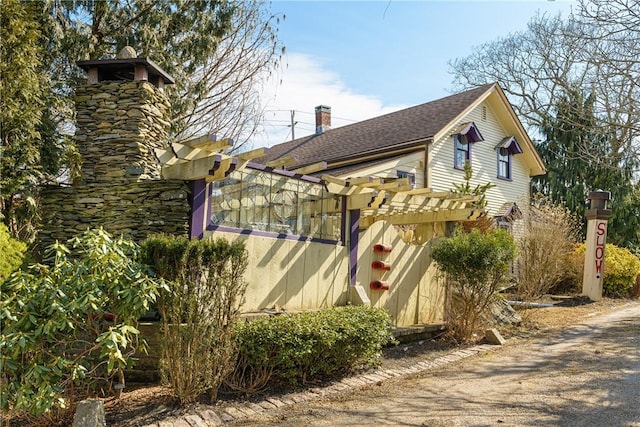 view of home's exterior with a shingled roof and a chimney