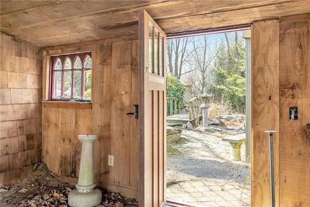 doorway to outside featuring wooden walls