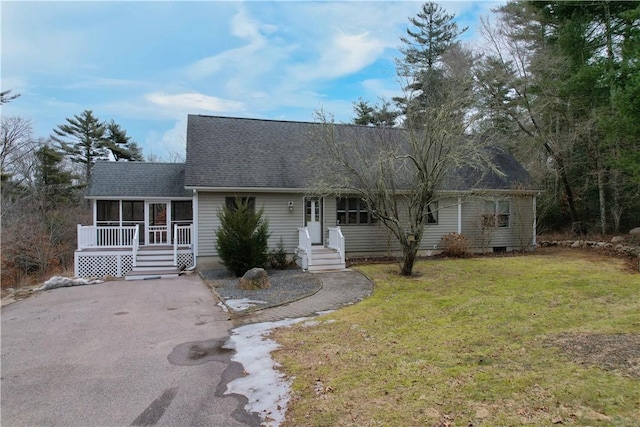 view of front of property featuring driveway, a front lawn, and a shingled roof