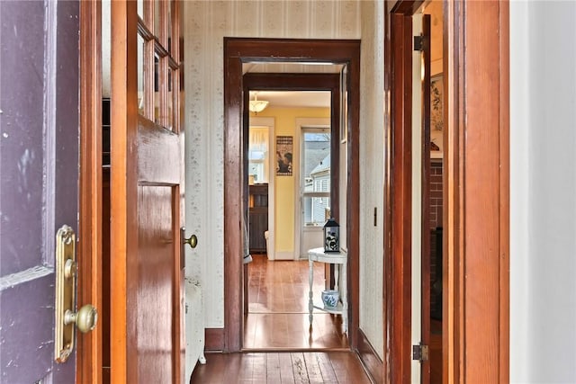 hall featuring wallpapered walls and wood-type flooring