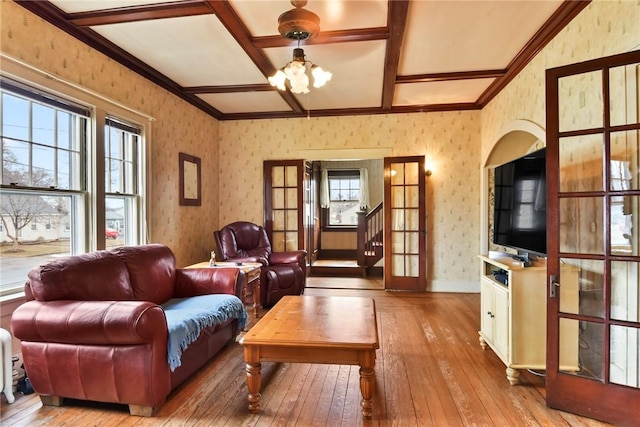 living room with a notable chandelier, coffered ceiling, beam ceiling, hardwood / wood-style floors, and wallpapered walls