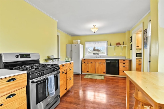 kitchen with dark wood finished floors, ornamental molding, stainless steel appliances, light countertops, and a sink