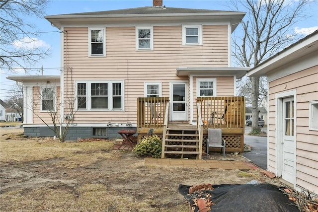 rear view of property featuring a chimney and a wooden deck