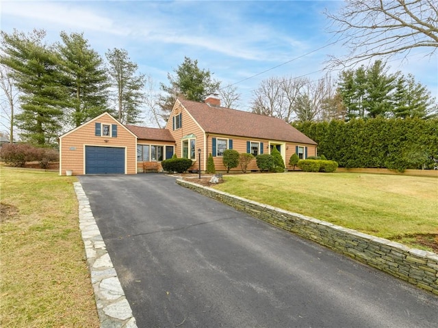 view of front of house featuring aphalt driveway, a front lawn, a chimney, and a shingled roof