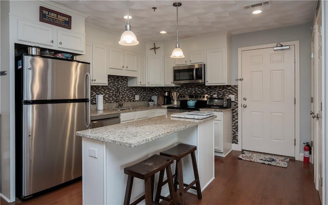 kitchen featuring stainless steel appliances, visible vents, a sink, and white cabinetry