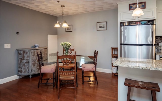 dining room featuring baseboards, a chandelier, and dark wood-style flooring