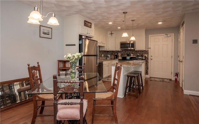 dining room featuring baseboards, dark wood-type flooring, and recessed lighting