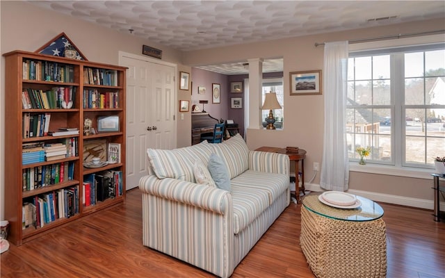 sitting room featuring visible vents, baseboards, and wood finished floors