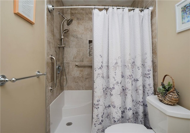 bathroom featuring a stall shower and toilet