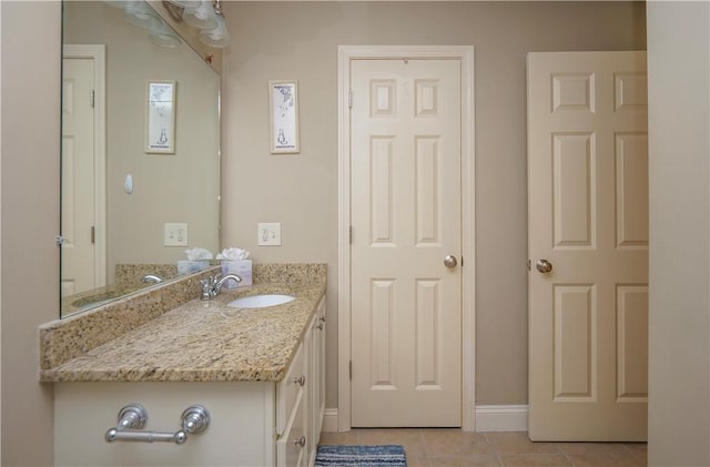 bathroom featuring tile patterned flooring, vanity, and baseboards