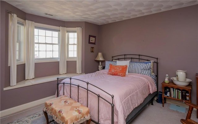 carpeted bedroom featuring visible vents