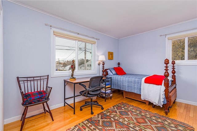 bedroom featuring ornamental molding, baseboards, and wood finished floors