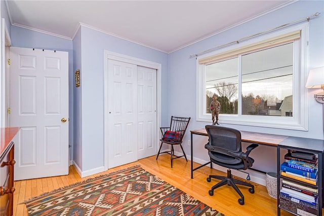 office featuring light wood-style floors, baseboards, and crown molding