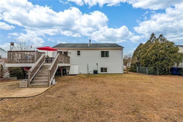 rear view of house with a lawn, a patio area, fence, a deck, and stairs