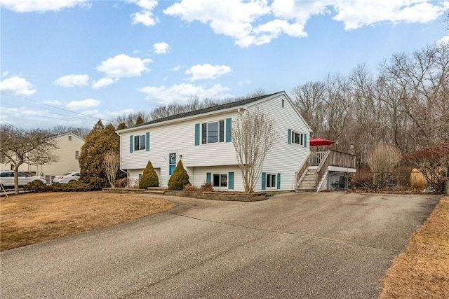 split foyer home with driveway, a front lawn, and stairs