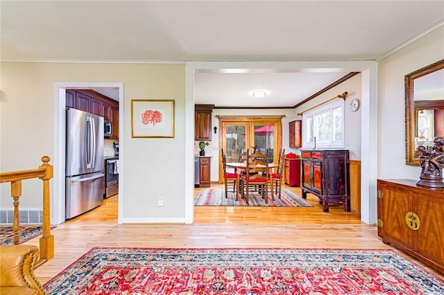 dining space with ornamental molding, visible vents, and light wood-style floors