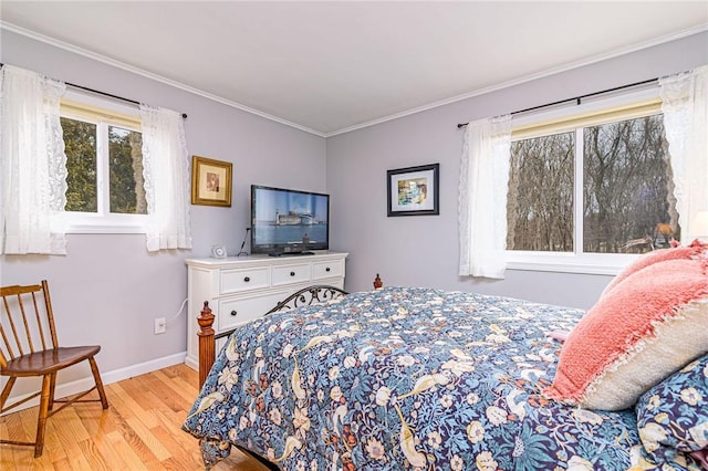 bedroom featuring ornamental molding, baseboards, and wood finished floors