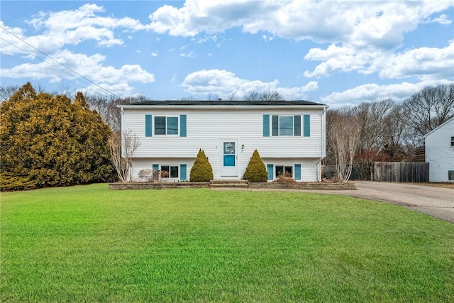 split foyer home featuring a front yard and fence