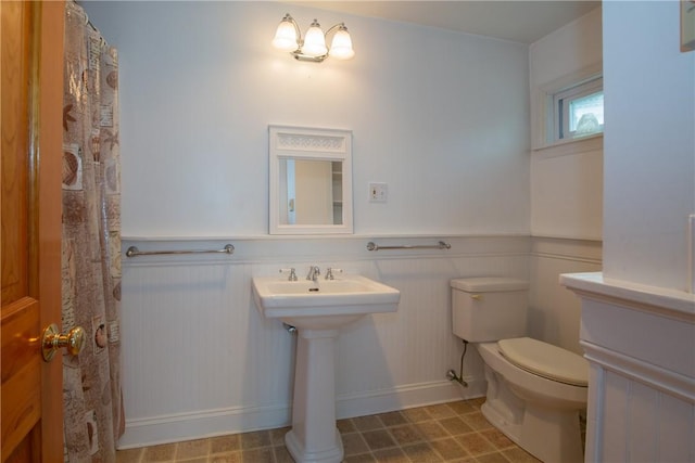 bathroom with toilet and wainscoting