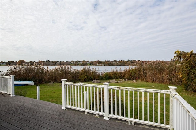 wooden deck with a lawn and a water view