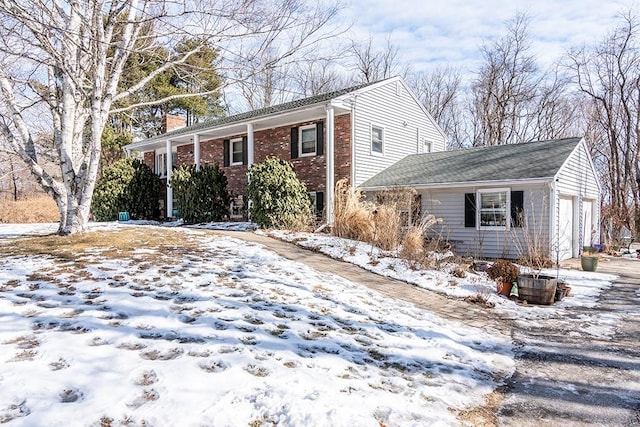 view of front of house with brick siding, a chimney, and an attached garage