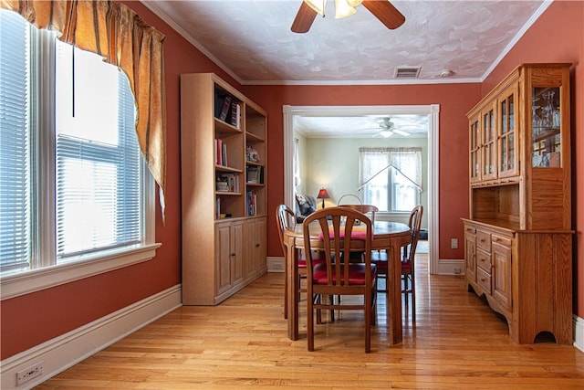 dining area with light wood-style flooring, visible vents, ornamental molding, and baseboards